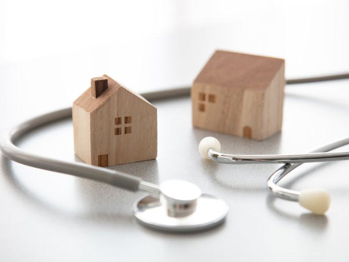 Model homes beside a stethoscope, representing home health and hospice care